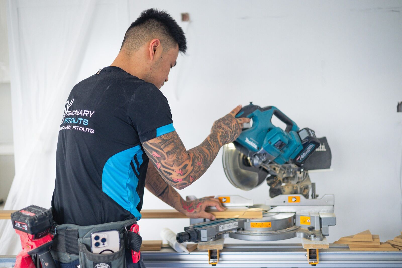 Carpenter checking a moulding against the saw fence
