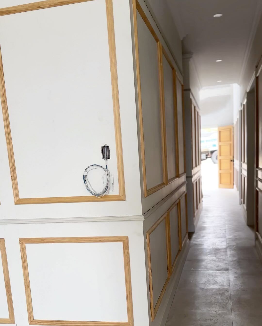 Hallway with white panelled walls, skirtings and architraves
