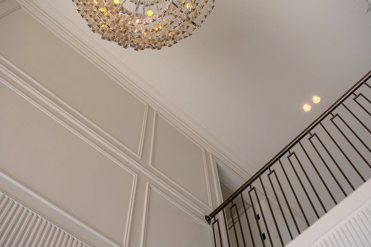 White panelled wall with applied mouldings beside a staircase